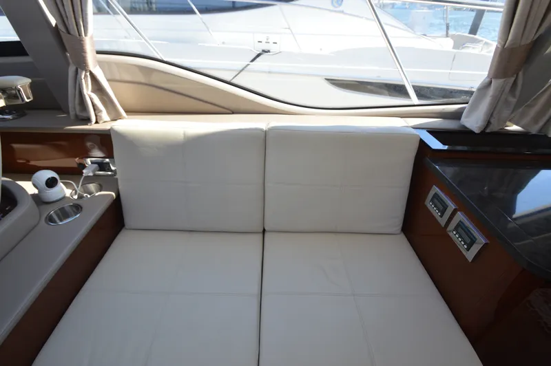 Slide: The Image of Interior of a 2018 Sea Ray 460 Express Cruiser with beige leather sofa and windows. - 26