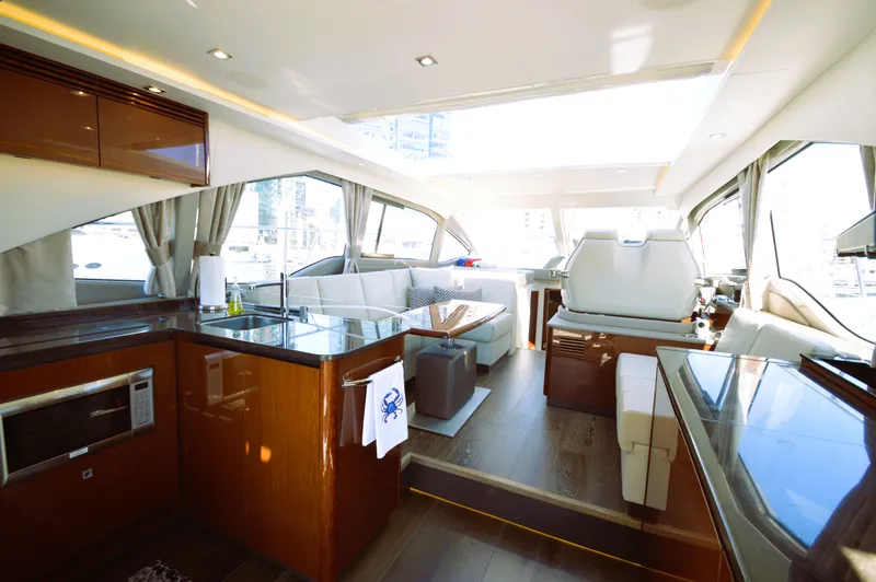Slide: The Image of Luxurious interior of a 2018 Sea Ray 460 Express Cruiser with modern kitchen and seating area. - 19