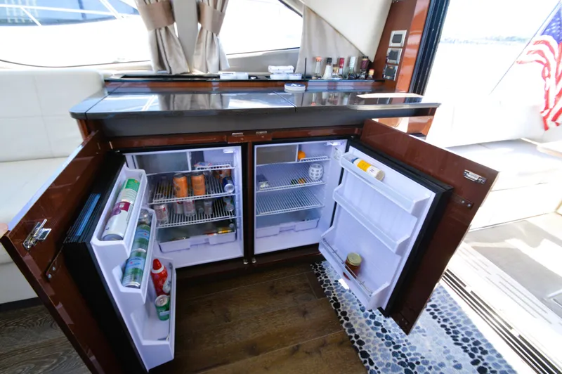 Slide: The Image of The 2018 Sea Ray 460 Express Cruiser features an open galley with two refrigerators. - 29
