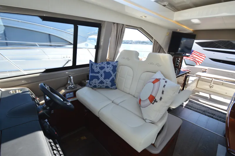 Slide: The Image of Interior of a 2018 Sea Ray 460 Express Cruiser with white leather seats and decorative pillows. - 32