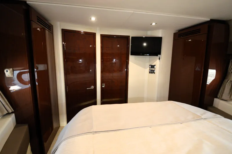 Slide: The Image of The cabin of a 2018 Sea Ray 460 Express Cruiser with a bed and a TV. - 49