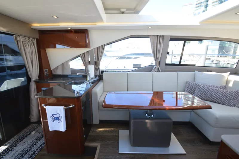 Slide: The Image of Interior of a 2018 Sea Ray 460 Express Cruiser with elegant seating area and kitchenette. - 22