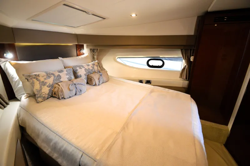 Slide: The Image of Luxurious bedroom with a large bed, elegant pillows, and a porthole for natural light. - 48