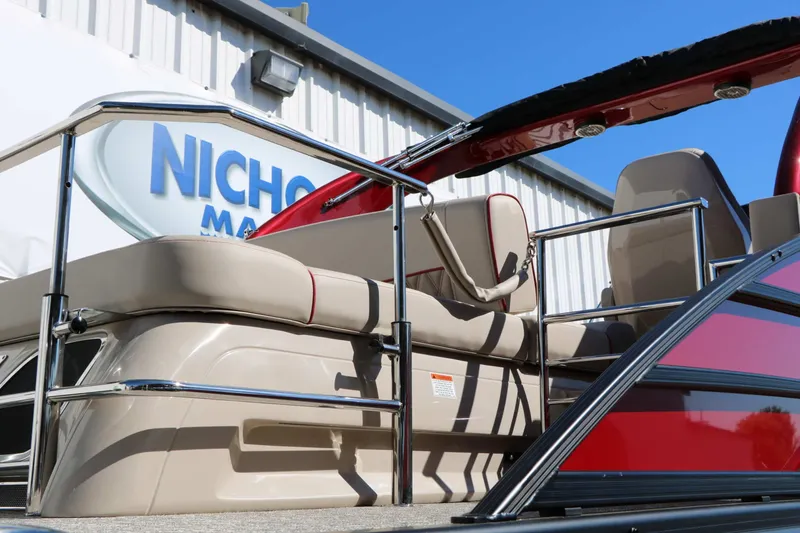 Slide: The Image of The image shows a Bennington 25 QSBA Tri Toon boat with red accents and beige seating. - 34