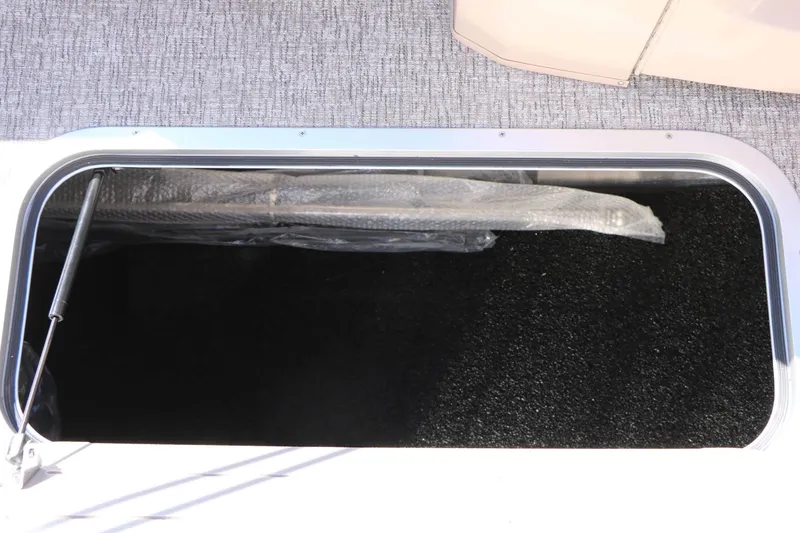Slide: The Image of A storage compartment with black carpet lining and a gas strut. - 47