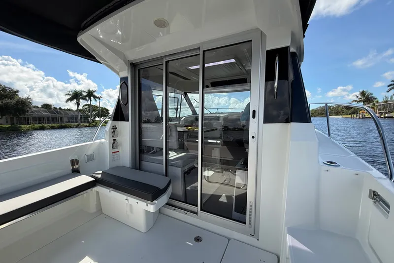 Slide: The Image of 2022 Jeanneau NC 795 Series 2 boat with sliding glass doors and scenic water view. - 20