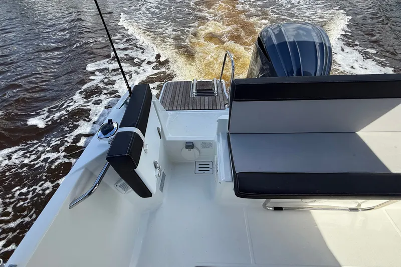 Slide: The Image of 2022 Jeanneau NC 795 Series 2 boat, rear view with seating and motor on water. - 23