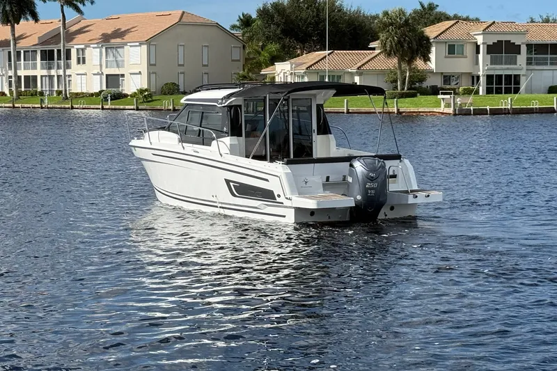 Slide: The Image of 2022 Jeanneau NC 795 Series 2 boat on a calm waterfront, residential backdrop. - 1