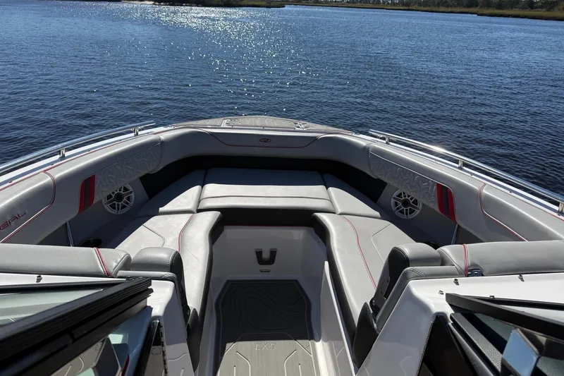 Slide: The Image of 2024 Regal LX9 boat interior with luxurious seating on a calm lake. - 13