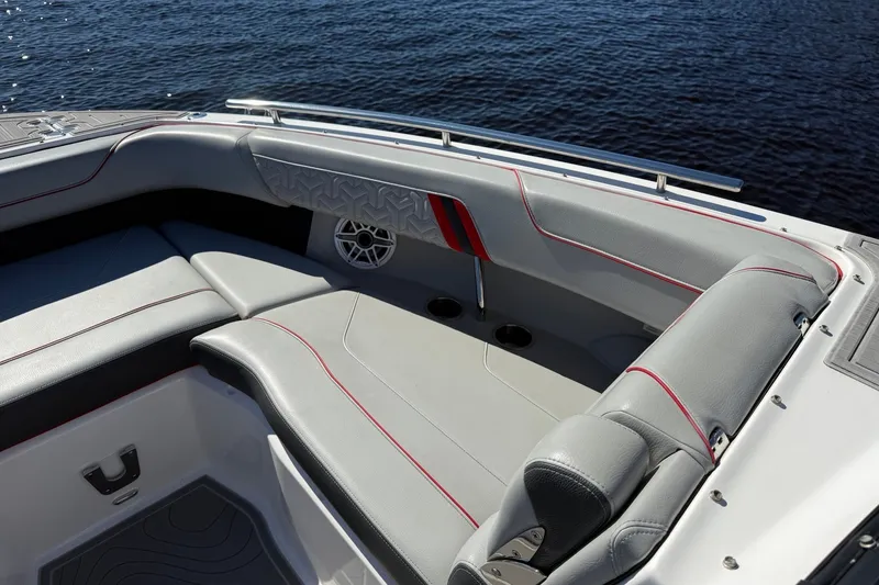 Slide: The Image of 2024 Regal LX9 boat interior with gray seating and red accents on the water. - 18