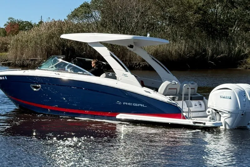 The Image of 2024 Regal LX9 boat with Yamaha engine cruising on a calm river. - 0