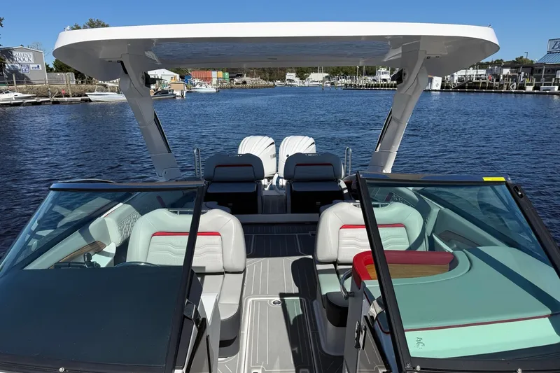 Slide: The Image of 2024 Regal LX9 boat with sleek seating and modern design on a calm waterfront. - 22