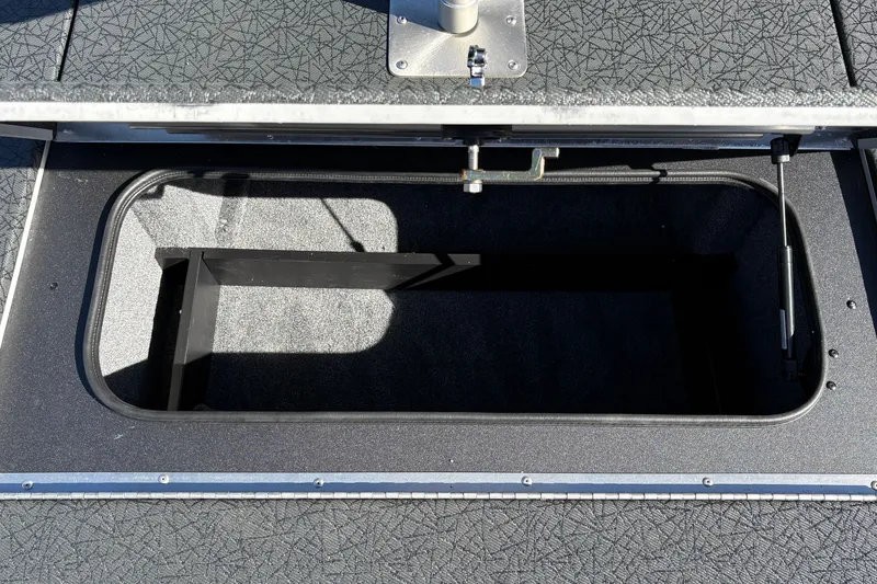 Slide: The Image of Open storage compartment in 2027 Tracker Pro Team 195 boat, featuring textured flooring. - 39