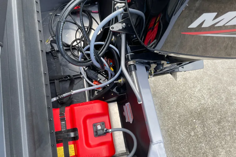 Slide: The Image of 2027 Tracker Pro 170 boat engine compartment with cables and red fuel tank. - 23