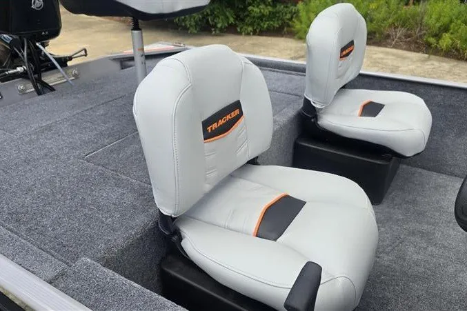 Slide: The Image of 2027 Tracker Bass Tracker Classic Limited boat seats, gray with orange accents, on deck. - 14