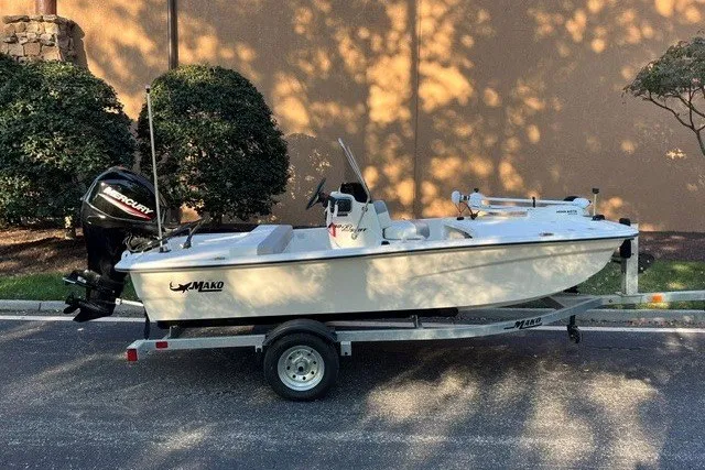 Slide: The Image of 2026 Mako Pro Skiff 13 CC boat on trailer, parked outdoors. - 1