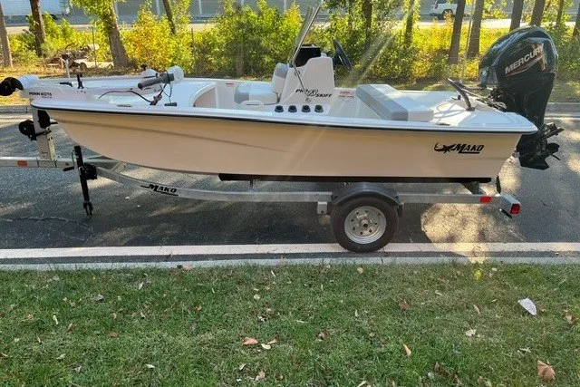 Slide: The Image of 2026 Mako Pro Skiff 13 CC boat on trailer, parked outdoors. - 2
