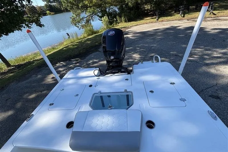 Slide: The Image of 2026 Mako 18 Pro Skiff boat with motor, parked near a serene lake. - 20
