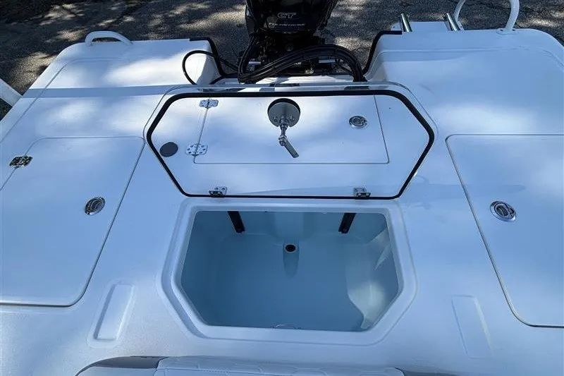 Slide: The Image of 2026 Mako 18 Pro Skiff boat deck with open storage compartment and motor. - 24