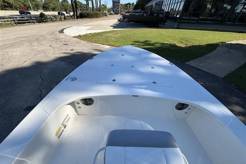 Slide: The Image of 2026 Mako 18 Pro Skiff boat, white interior, parked outdoors on a sunny day. - 11