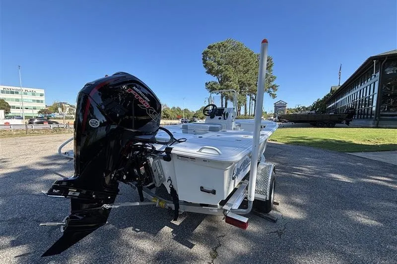 Slide: The Image of 2026 Mako 18 Pro Skiff boat on trailer, parked outdoors under clear sky. - 6