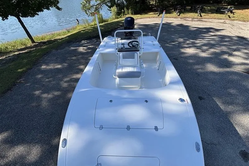 Slide: The Image of 2026 Mako 18 Pro Skiff boat parked near a serene lakeside setting. - 10