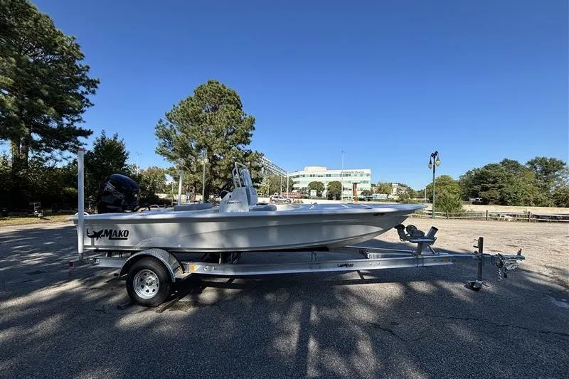Slide: The Image of 2026 Mako 18 Pro Skiff boat on trailer, parked outdoors under clear blue sky. - 5