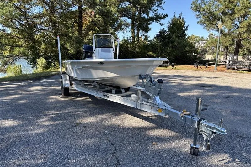 Slide: The Image of 2026 Mako 18 Pro Skiff boat on trailer, parked outdoors near trees. - 4