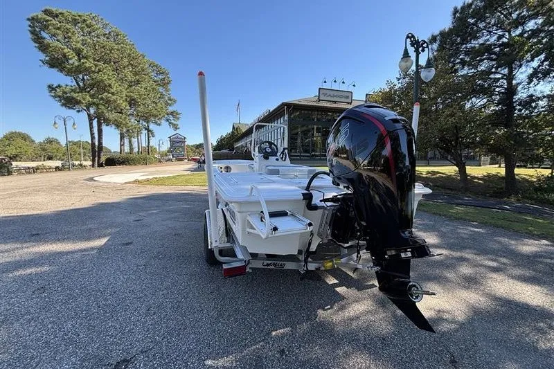 Slide: The Image of 2026 Mako 18 Pro Skiff boat with outboard motor on a trailer, parked outdoors. - 8