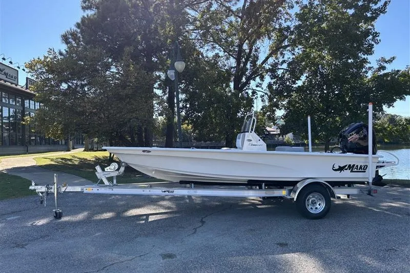 Slide: The Image of 2026 Mako 18 Pro Skiff on trailer by a lakeside, surrounded by trees. - 1