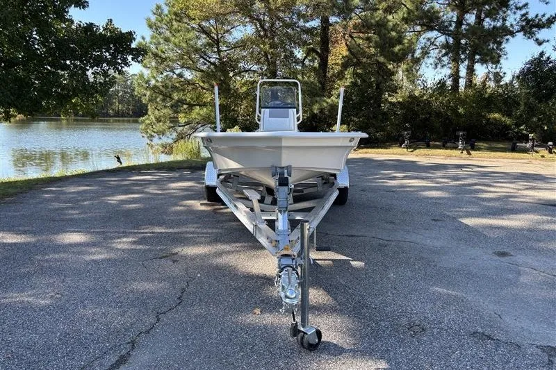 Slide: The Image of 2026 Mako 18 Pro Skiff boat on trailer by a scenic lake. - 3