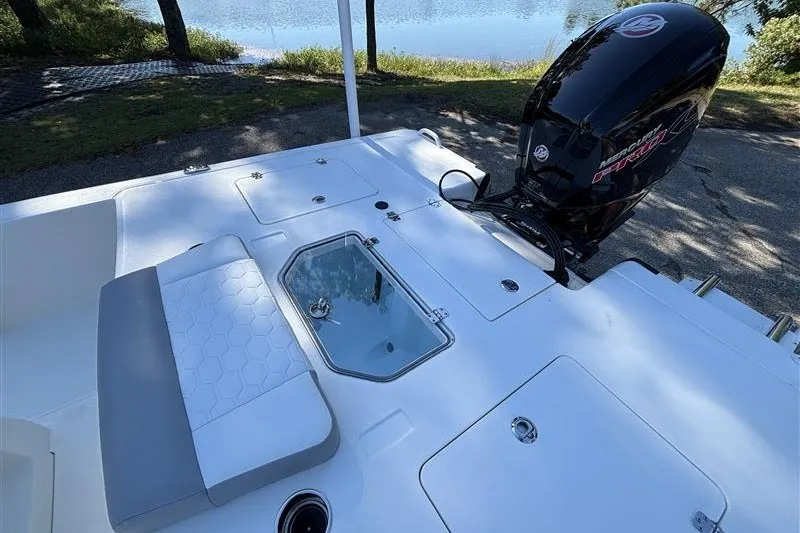 Slide: The Image of 2026 Mako 18 Pro Skiff boat with outboard motor, near a serene lake. - 19