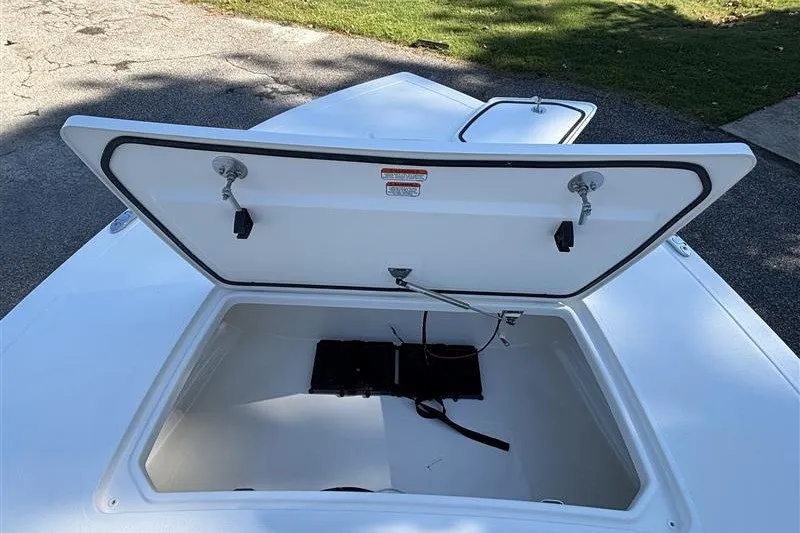 Slide: The Image of Open storage compartment of 2026 Mako 18 Pro Skiff boat on pavement. - 13