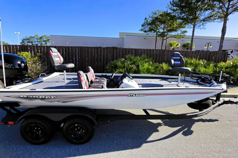 Slide: The Image of 2027 Ranger RT198P fishing boat on trailer, parked outdoors under clear blue sky. - 2