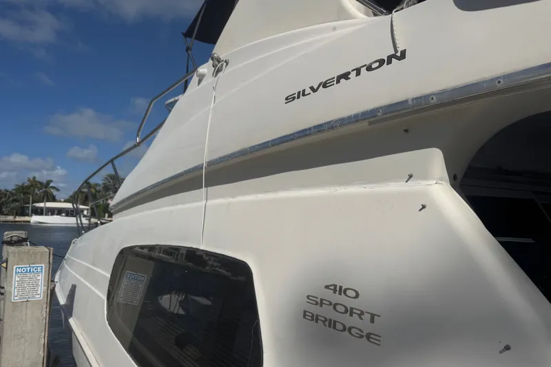 Slide: The Image of 2002 Silverton 410 Sport Bridge yacht docked under a clear blue sky. - 57
