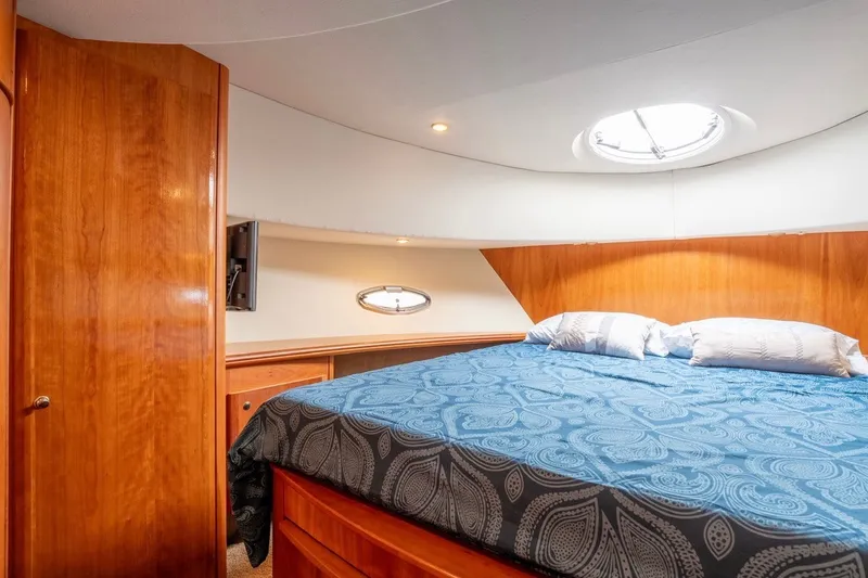 Slide: The Image of Luxurious cabin interior of 2002 Silverton 410 Sport Bridge with cozy bed and wooden accents. - 17