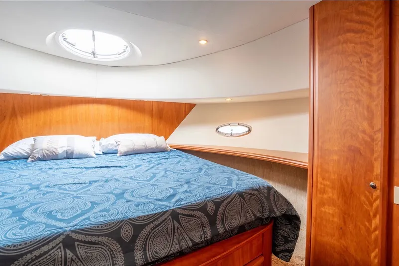 Slide: The Image of Luxurious cabin interior of 2002 Silverton 410 Sport Bridge with cozy bed and elegant wood finish. - 18
