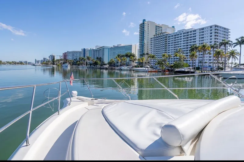 Slide: The Image of 2002 Silverton 410 Sport Bridge yacht cruising near waterfront cityscape with palm trees. - 8