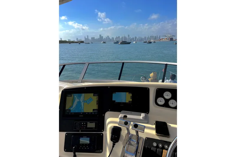 Slide: The Image of Helm view from 2002 Silverton 410 Sport Bridge, overlooking a bustling harbor and city skyline. - 7