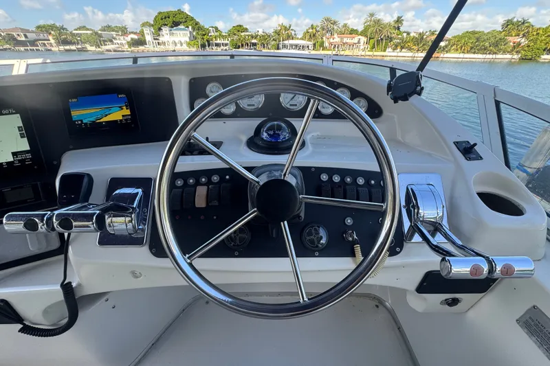 Slide: The Image of Steering wheel and controls of a 2002 Silverton 410 Sport Bridge yacht. - 17