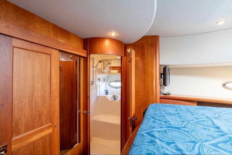 Slide: The Image of Interior of 2002 Silverton 410 Sport Bridge with wood paneling and cozy cabin layout. - 14