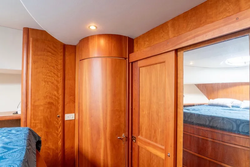 Slide: The Image of Interior of 2002 Silverton 410 Sport Bridge with wooden cabinetry and cozy bedroom. - 13