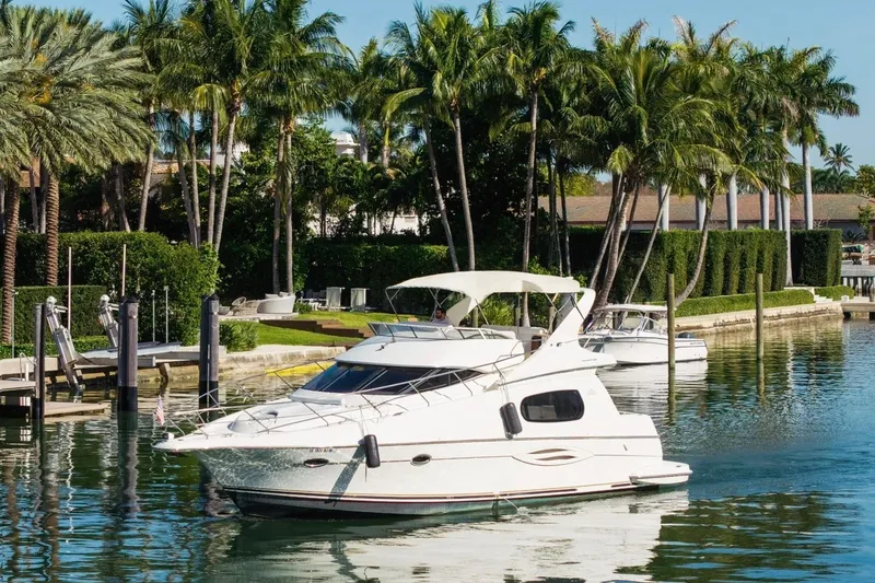 Slide: The Image of 2002 Silverton 410 Sport Bridge yacht docked near palm trees in a serene marina. - 4