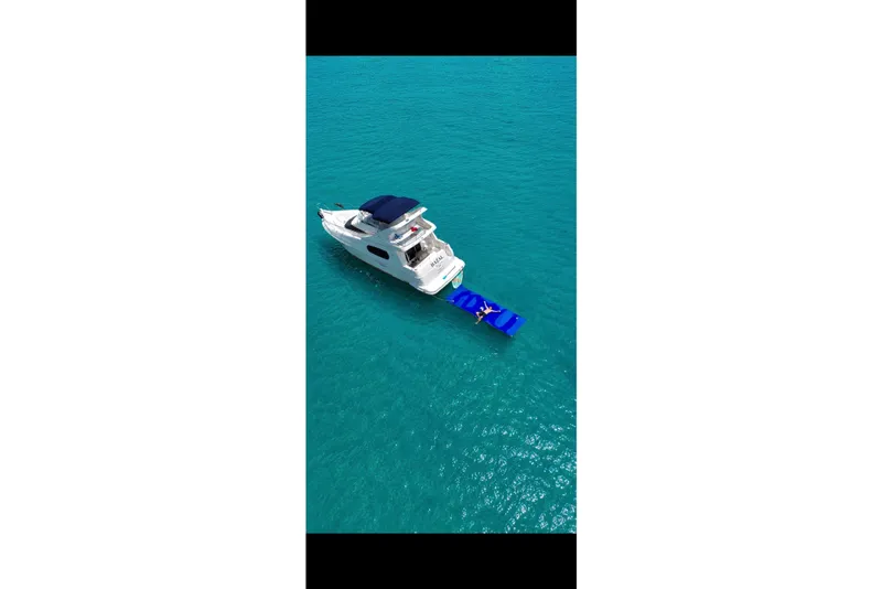 Slide: The Image of Aerial view of 2002 Silverton 410 Sport Bridge yacht on turquoise water. - 22