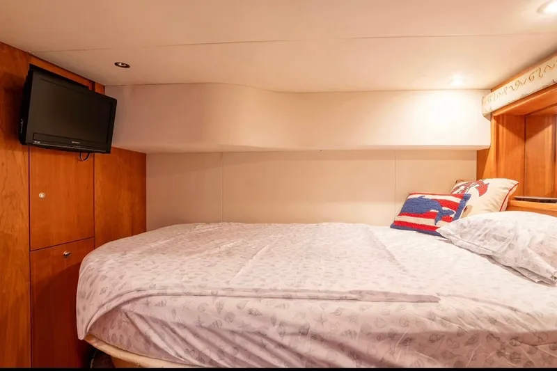 Slide: The Image of Cozy cabin interior of 2002 Silverton 410 Sport Bridge with bed and mounted TV. - 9