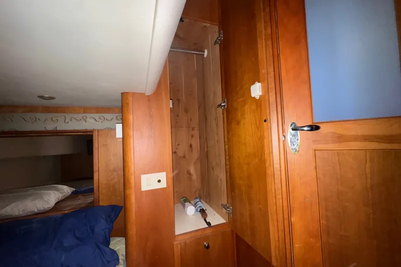 Slide: The Image of Interior of 2002 Silverton 410 Sport Bridge with wooden cabinetry and cozy sleeping area. - 50