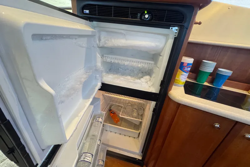 Slide: The Image of Open refrigerator in 2002 Silverton 410 Sport Bridge yacht kitchen, showing frost buildup and drinks. - 36