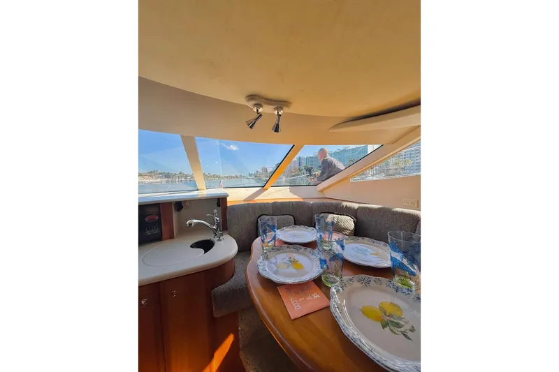Slide: The Image of Interior of 2002 Silverton 410 Sport Bridge yacht with dining setup and city view. - 21
