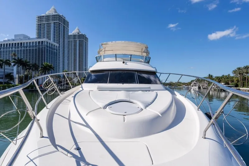 Slide: The Image of 2002 Silverton 410 Sport Bridge yacht docked near modern skyscrapers and palm trees. - 6