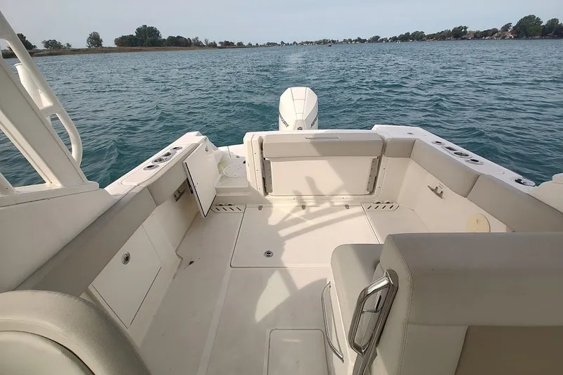 Slide: The Image of 2022 Boston Whaler 240 Vantage boat interior with seating, on calm water. - 35